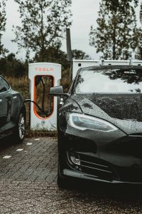 Charge a Tesla in the Rain. Photo by Andreas Dress on Unsplash
