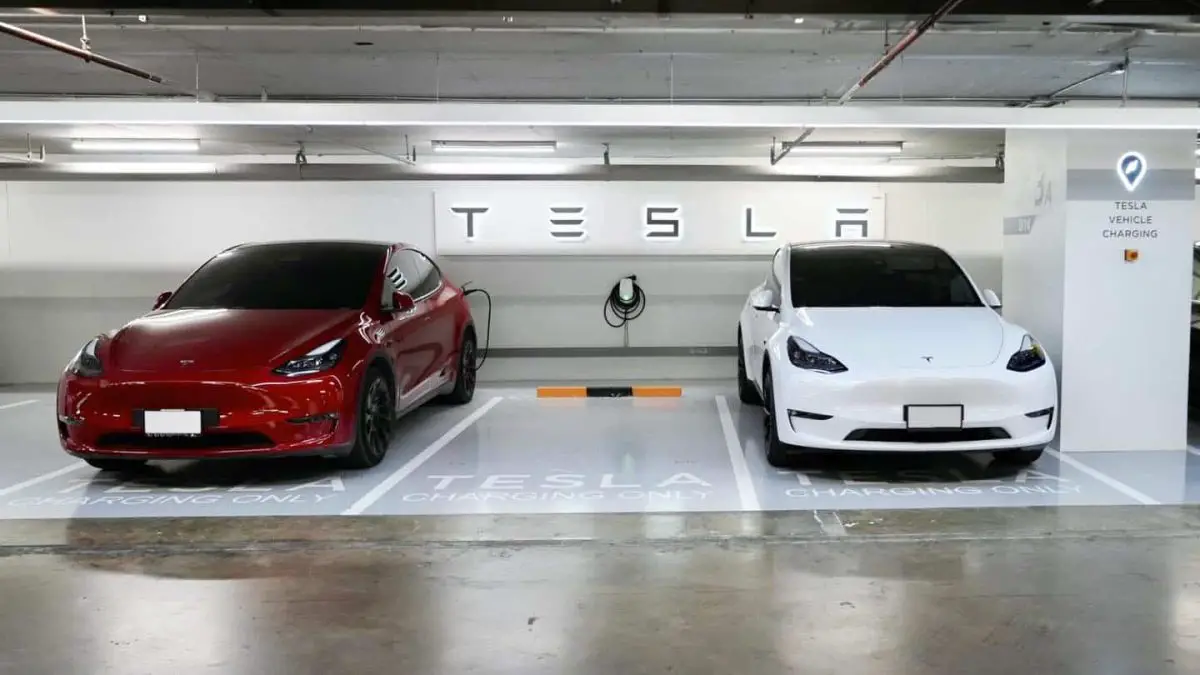 2 Tesla's parked in a Tesla Destination Charging station. The charging station is in a underground parking garage